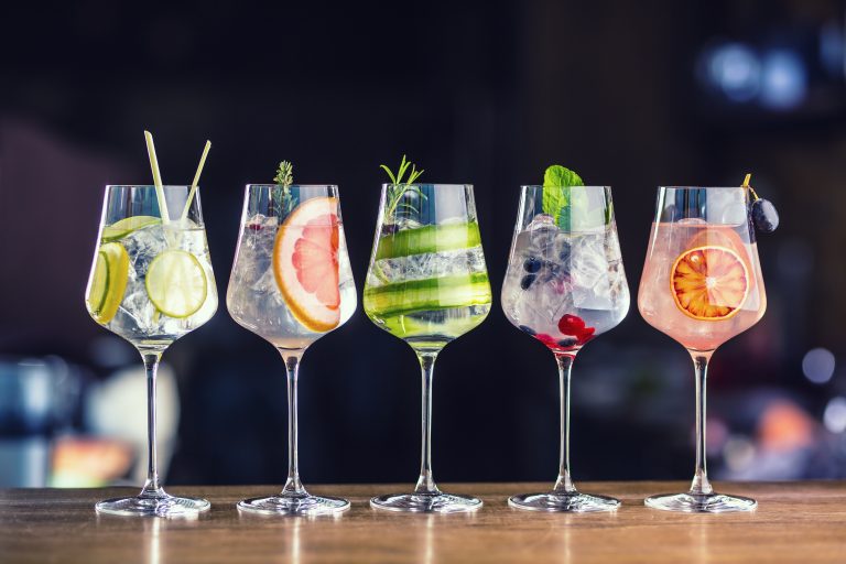 Five,Colorful,Gin,Tonic,Cocktails,In,Wine,Glasses,On,Bar