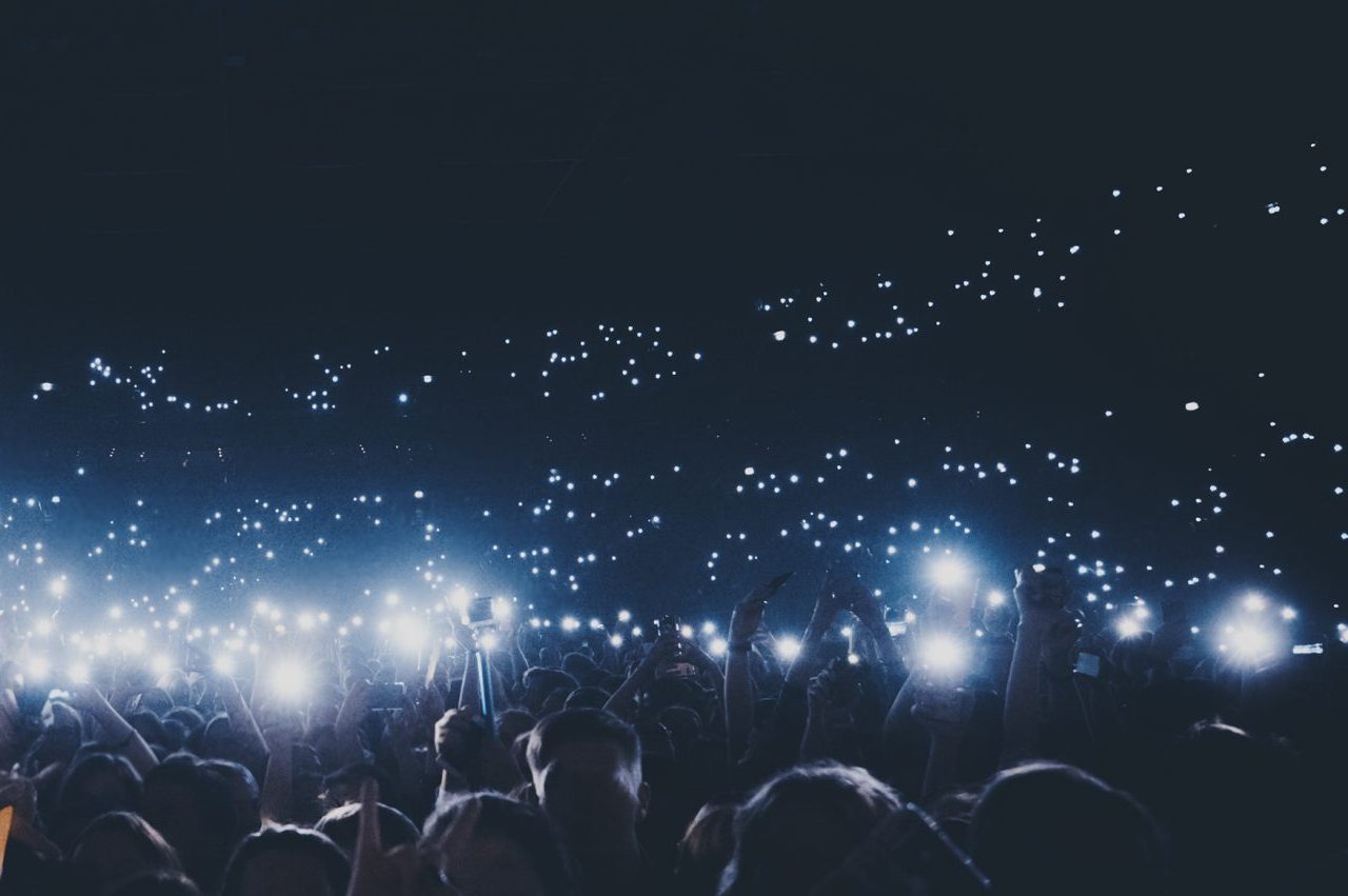 Group of people holding cigarette lighters and mobile phones at a concert