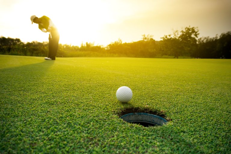 Golfer,Putting,Golf,Ball,On,The,Green,Golf,,Lens,Flare