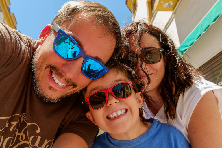 Family,Having,Fun,Wearing,Sunglasses,&,Waving,To,A,Camera