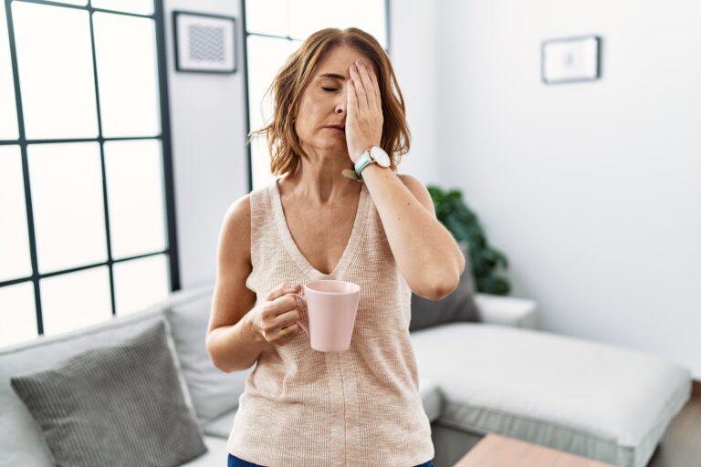 Middle,Age,Woman,Drinking,A,Cup,Coffee,At,Home,Yawning