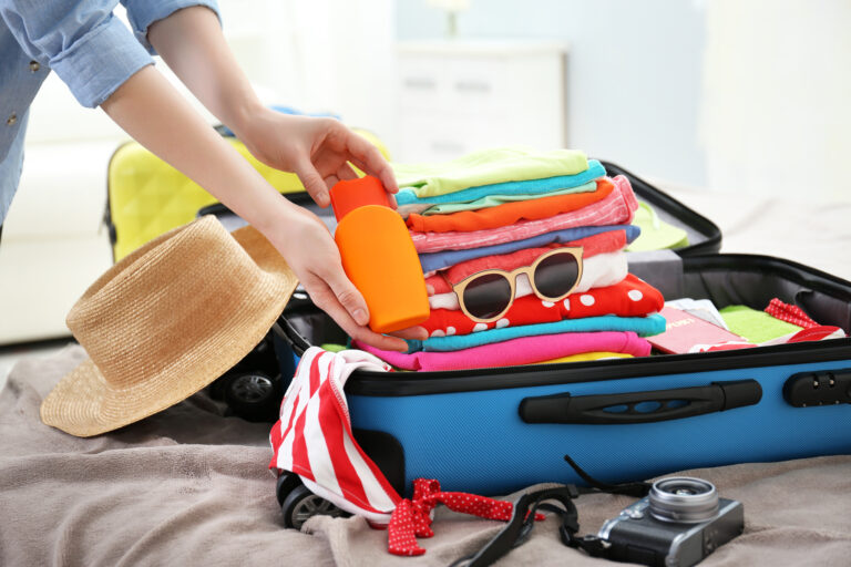 Female,Hands,Packing,Traveler,Case,On,Bed,,Closeup