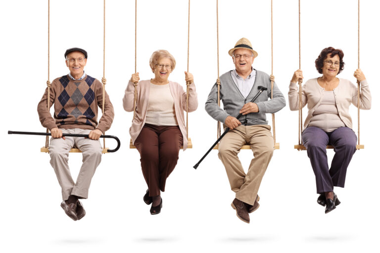 Cheerful,Seniors,Sitting,On,Wooden,Swings,And,Looking,At,The
